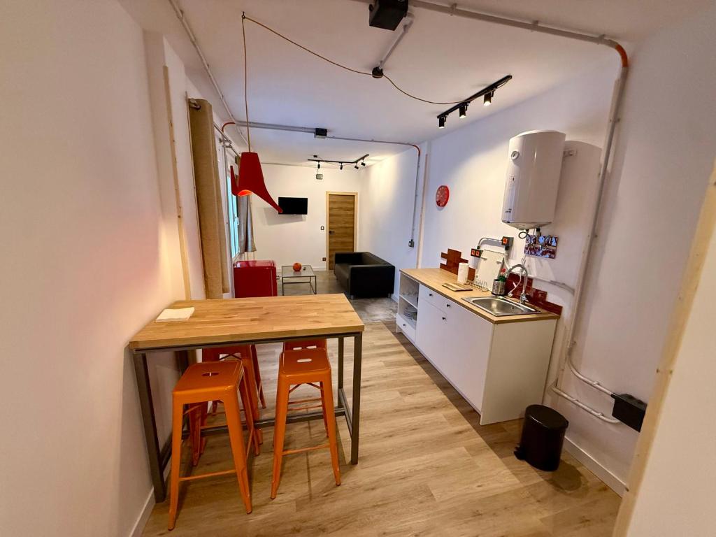 a kitchen with a table and chairs in a room at The Orange Teddy Bear Gijón in Gijón