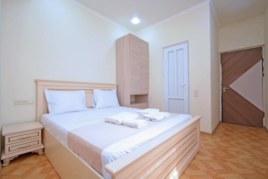 a bedroom with a large white bed with towels on it at Soma Apart-hotel in Center in Yerevan