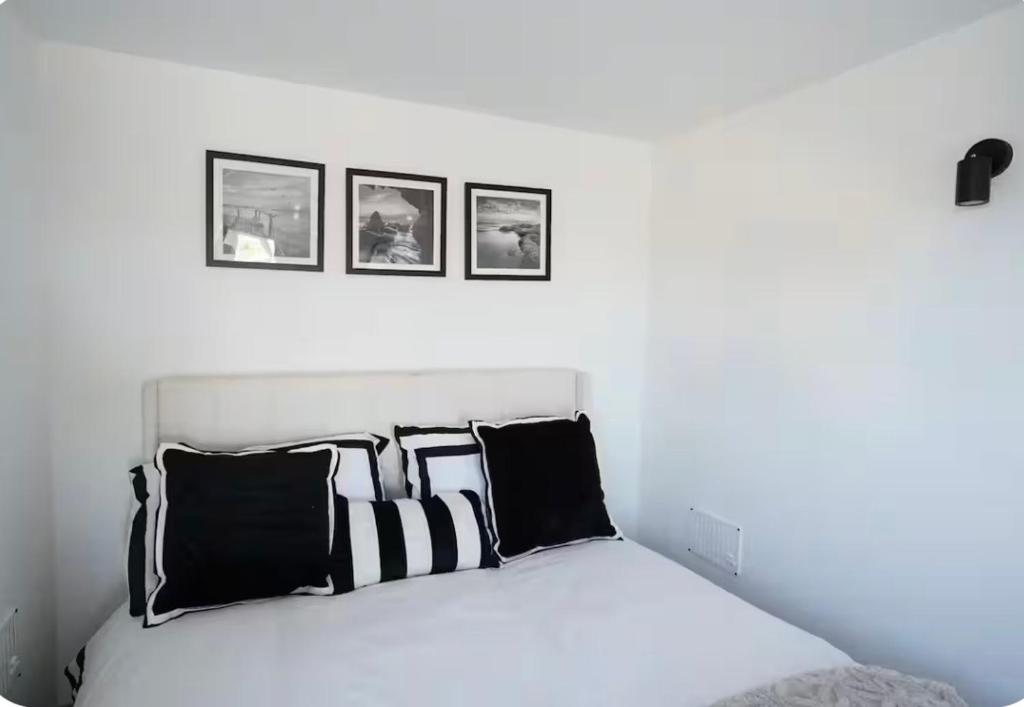 a bed with black and white pillows in a bedroom at Double room container in Berkley