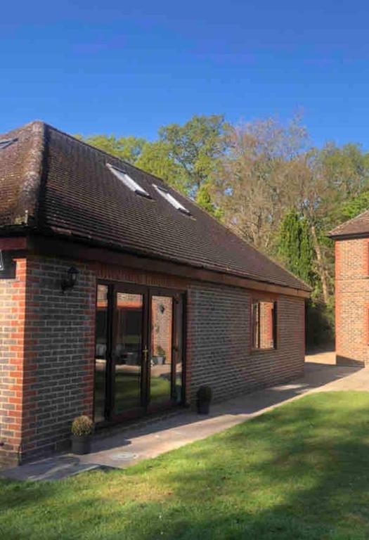 a brick building with glass doors on a lawn at Spacious and close to Gatwick in Crawley