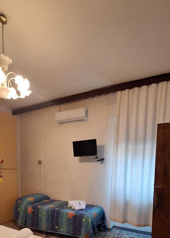 a room with two beds and a tv on the wall at B&B Sa Rocca Manna in Laerru