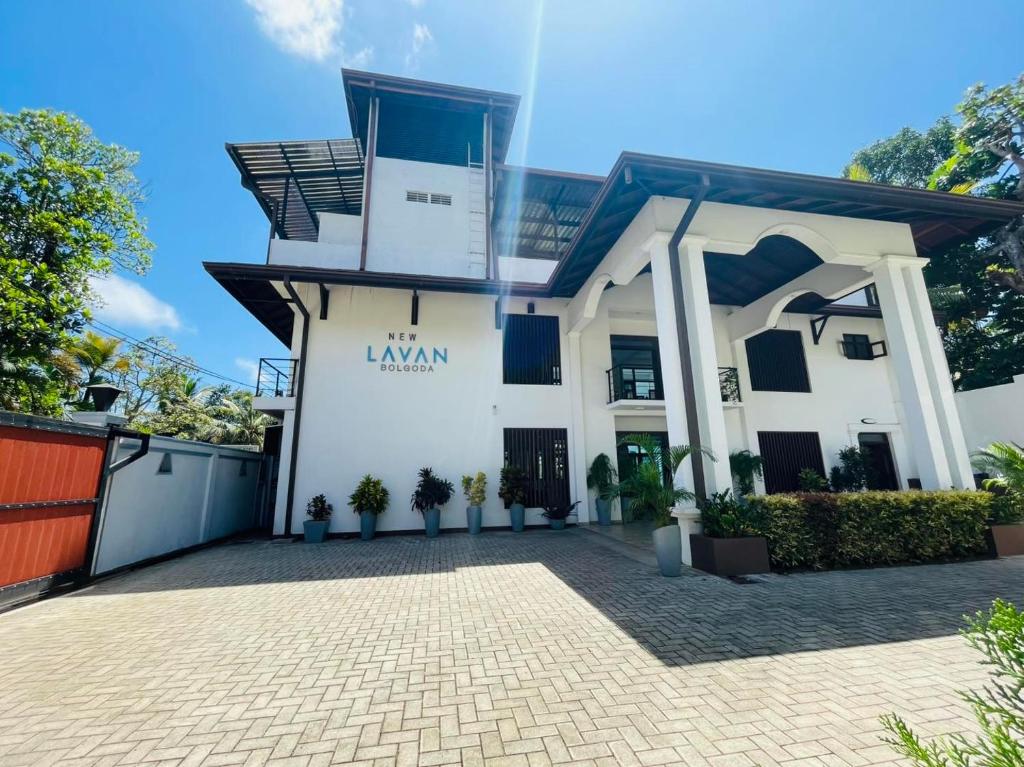 a large white building with a driveway at New Lavan Bolgoda in Piliyandala