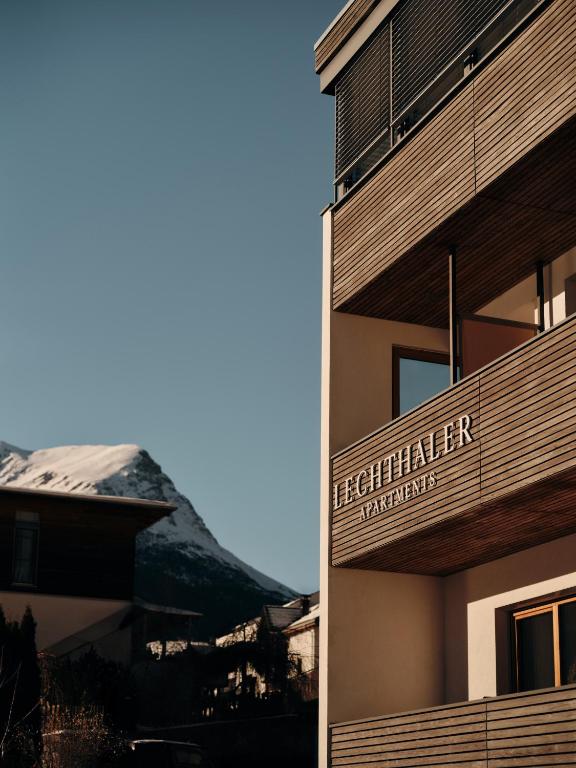 a sign on the side of a building with a snow covered mountain at Lechthaler Apartments in Resia