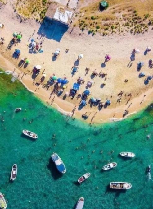 a group of people standing in the water at the beach at Penthouse Sea Apartment in El Mîna
