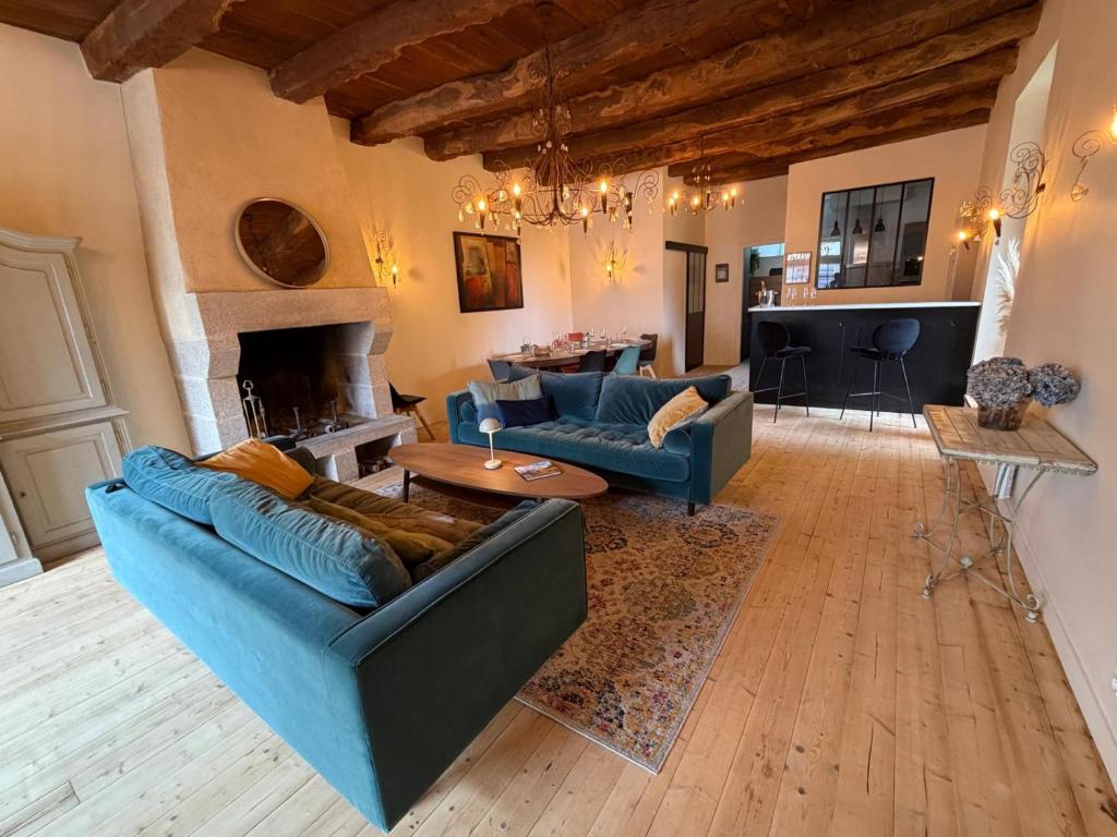 a living room with blue couches and a fireplace at Le Gîte du Prieuré in Josselin