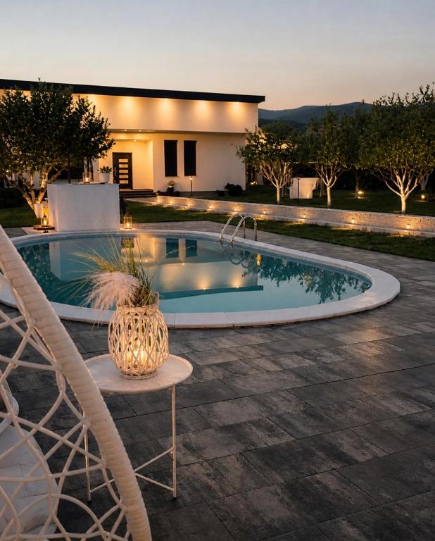 a swimming pool in front of a house at Relax Villa with Pool in Bihać