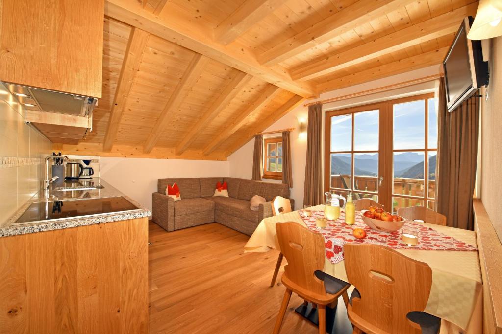 a kitchen and living room with a table and a couch at Feldererhof GsiesApt Dolomitenblick in Valle Di Casies