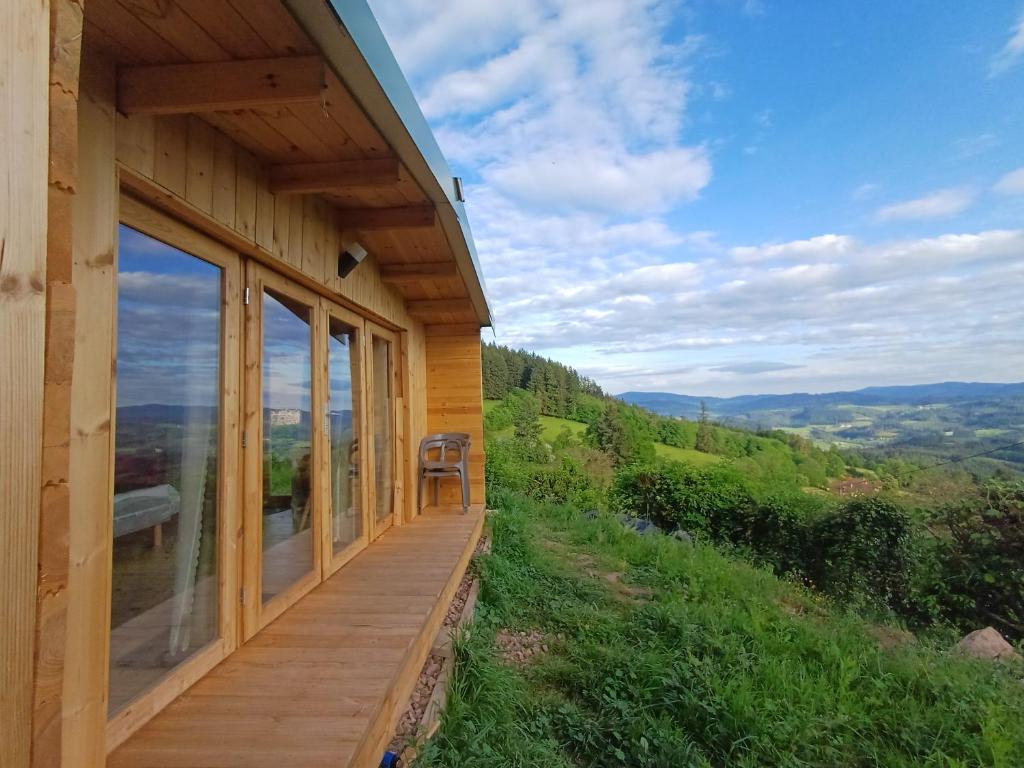 a wooden porch on a house with a view at Grand Chêne in Saint-Racho