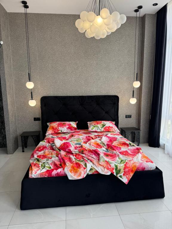 a bed with a floral comforter in a bedroom at Delmar Apartment Center in Dnipro
