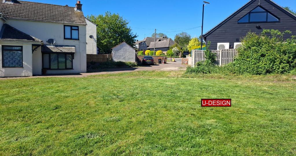 a red sign sitting in the grass in a yard at The Green Yard - Ebike Available for Guests in Sundon