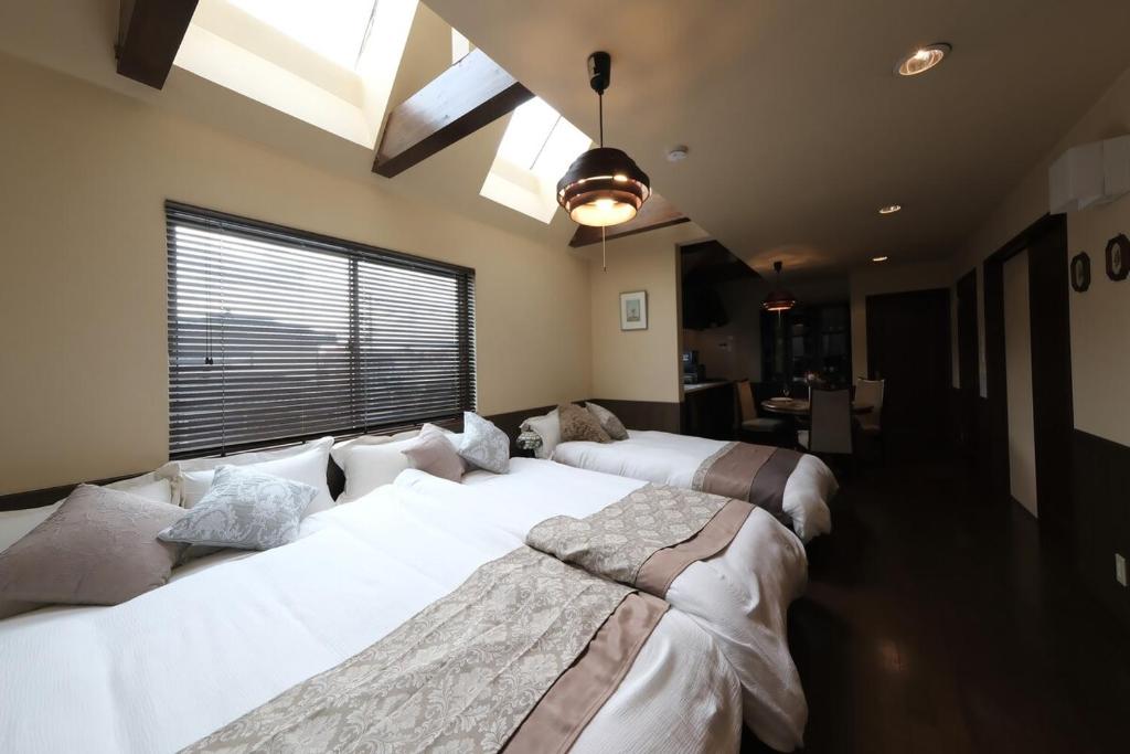 two beds in a room with a large window at KEI VILLA Tsujido in Takata
