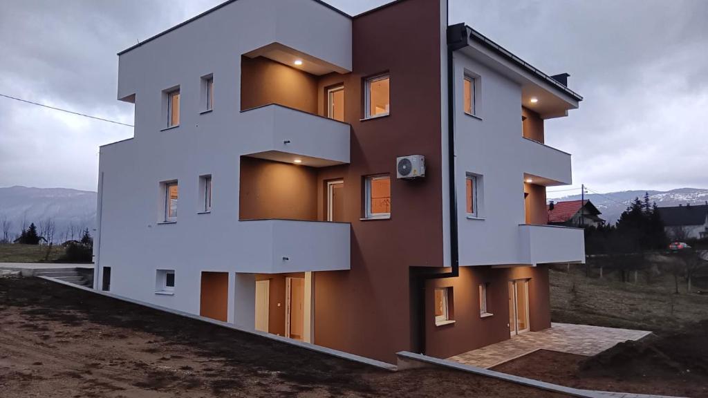 a building with white balconies on the side of it at Apartmani Jozić 2 in Ripci