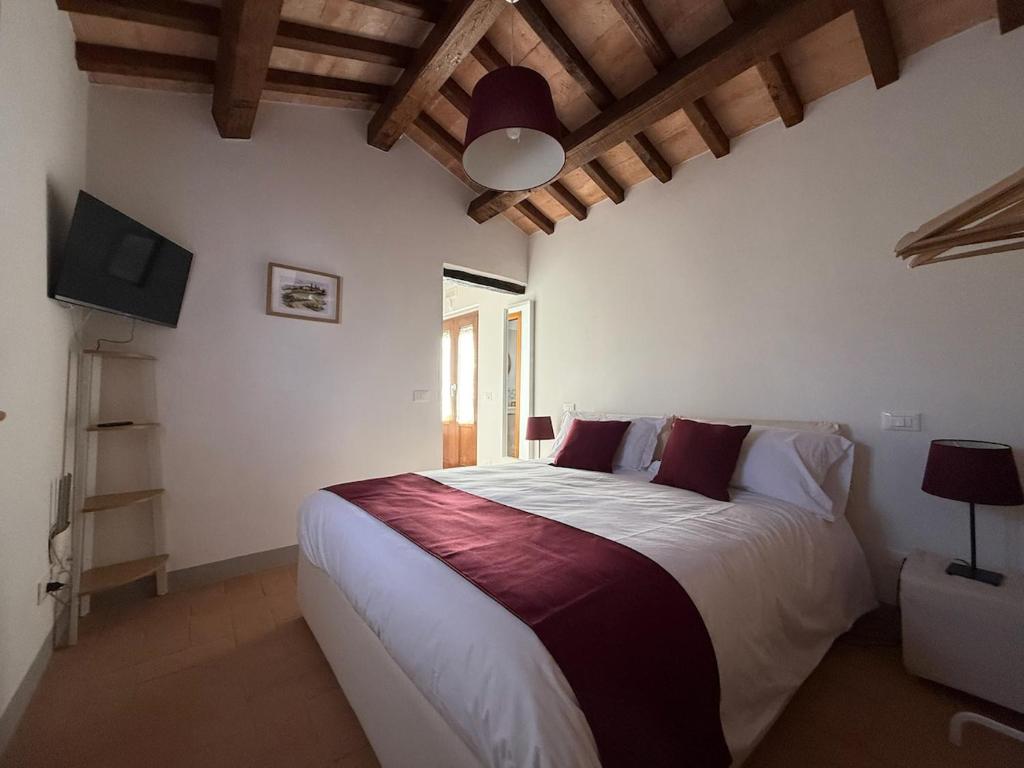 a bedroom with a large bed and a television at Il Casale del Tiglio in Monteleone dʼOrvieto