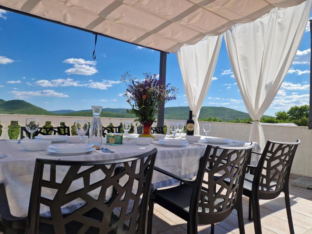 a table with wine glasses and a view of the ocean at Apartman Gizdavac in Gizdavac