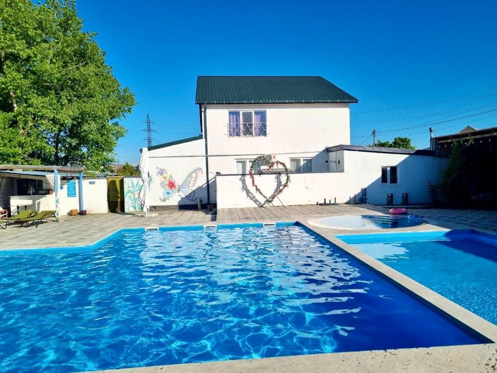 a house with a swimming pool in front of a building at Laguna House next to Pool at Bazaleti Lake in Bazalet'i