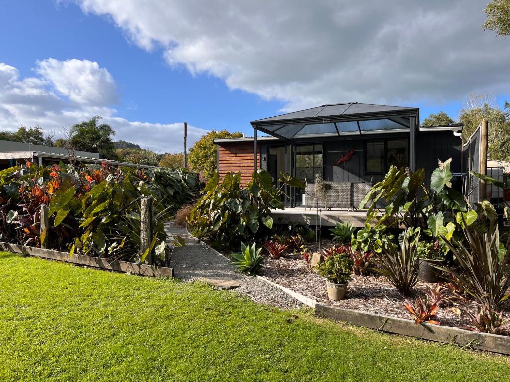 a house with a black roof and some plants at Awaroa Retreat in Whangarei