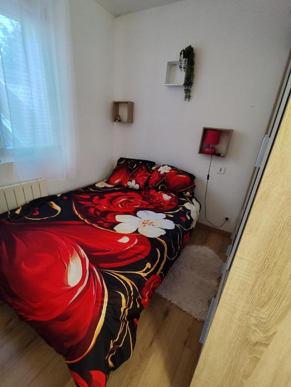 a bedroom with a bed with a colorful blanket at Appartement Centre Ville in Questembert
