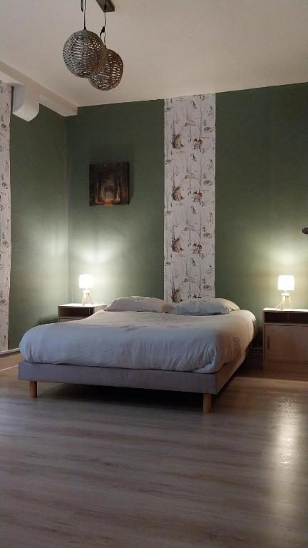 a bedroom with a large bed with green walls at 50 nuances de couleurs in Arinthod