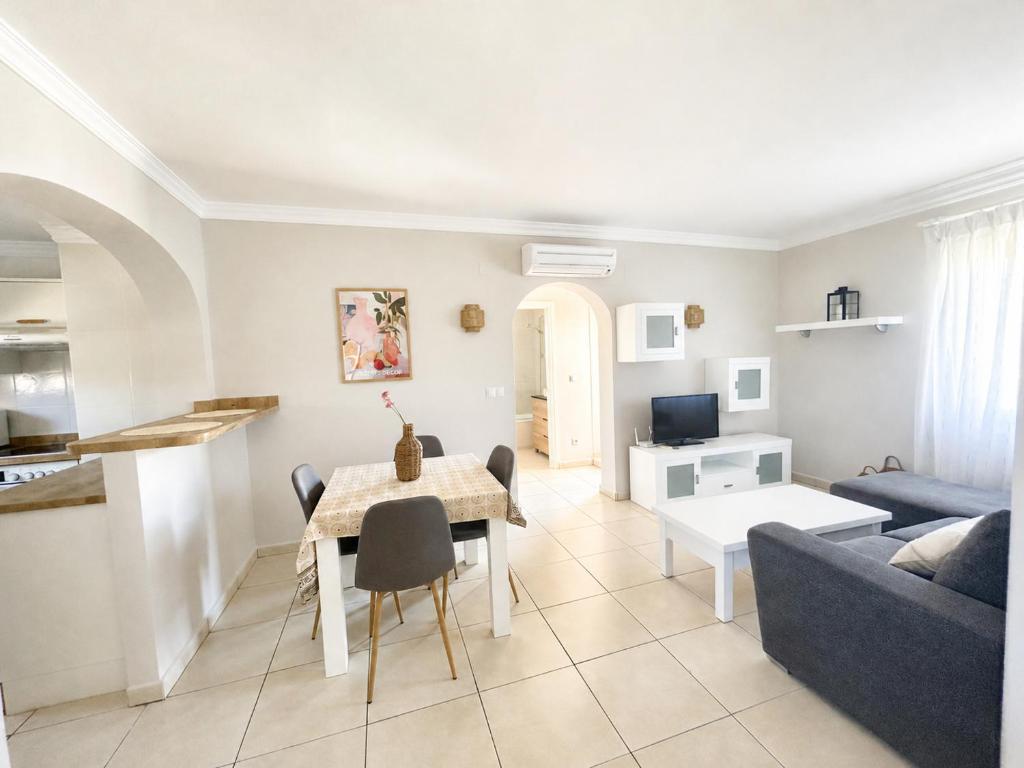 a living room with a table and a blue couch at Apartamento en Olivanova in Casas Devesa