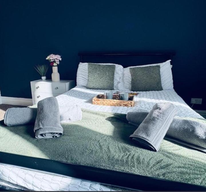 a bedroom with a large bed with a blue wall at Harrington House - Perfect for contractors Sleeps 15 in Workington