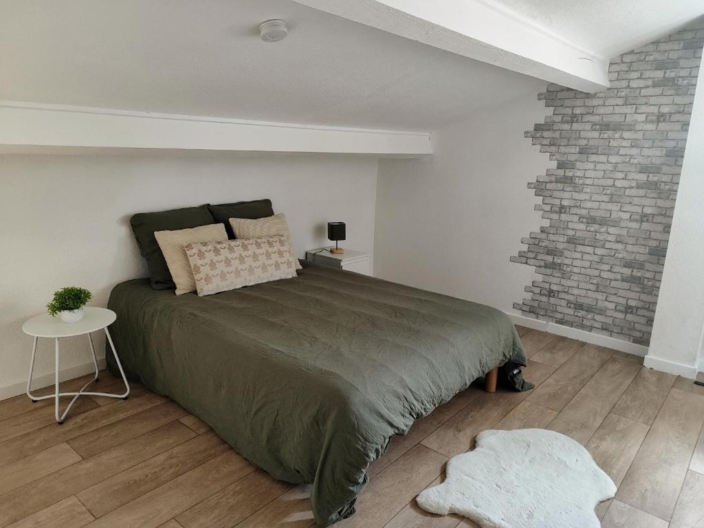 a bedroom with a large bed and a brick wall at Appartement en résidence Valras-Plage in Valras-Plage