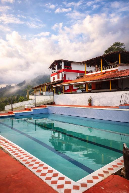 a swimming pool in front of a building at Finca la pilarica in Istmina