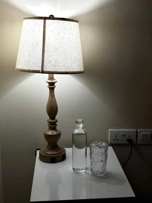 a bottle of water and a lamp on a table at Amber Home Kigali in Kigali
