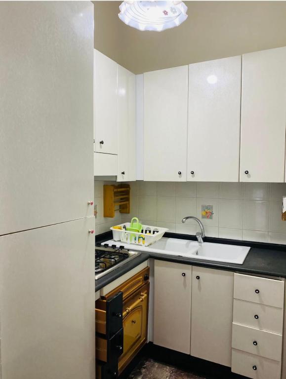 a kitchen with white cabinets and a sink at Casa palli in Camerota