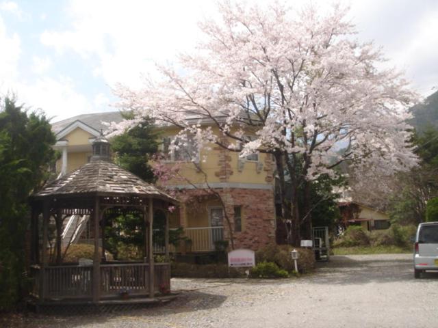 a gazebo in front of a house with a flowering tree at Ikoi in Nikko