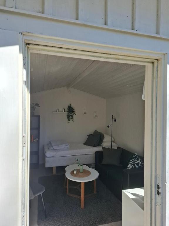 a living room with a couch and a bed at Gäststugan in Alingsås