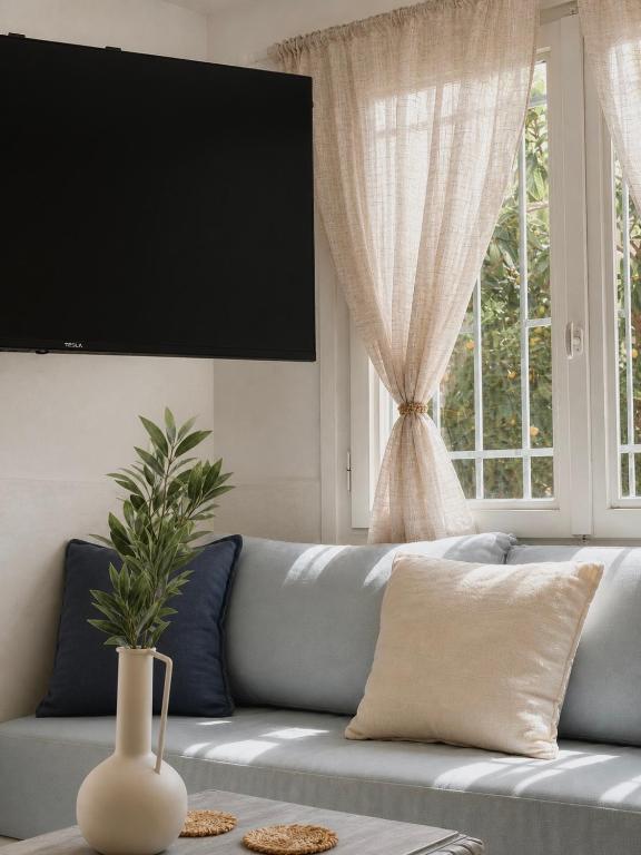 ein Wohnzimmer mit einer blauen Couch und einem Fenster in der Unterkunft Alkionis Studio in Vari