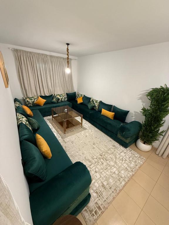 a living room with a green couch and a table at Dar Ifrane in Ifrane