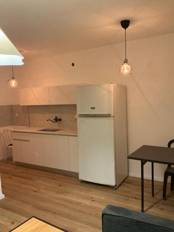 a kitchen with a white refrigerator and a table at דירת בוטיק מפנקת in Beer Sheva