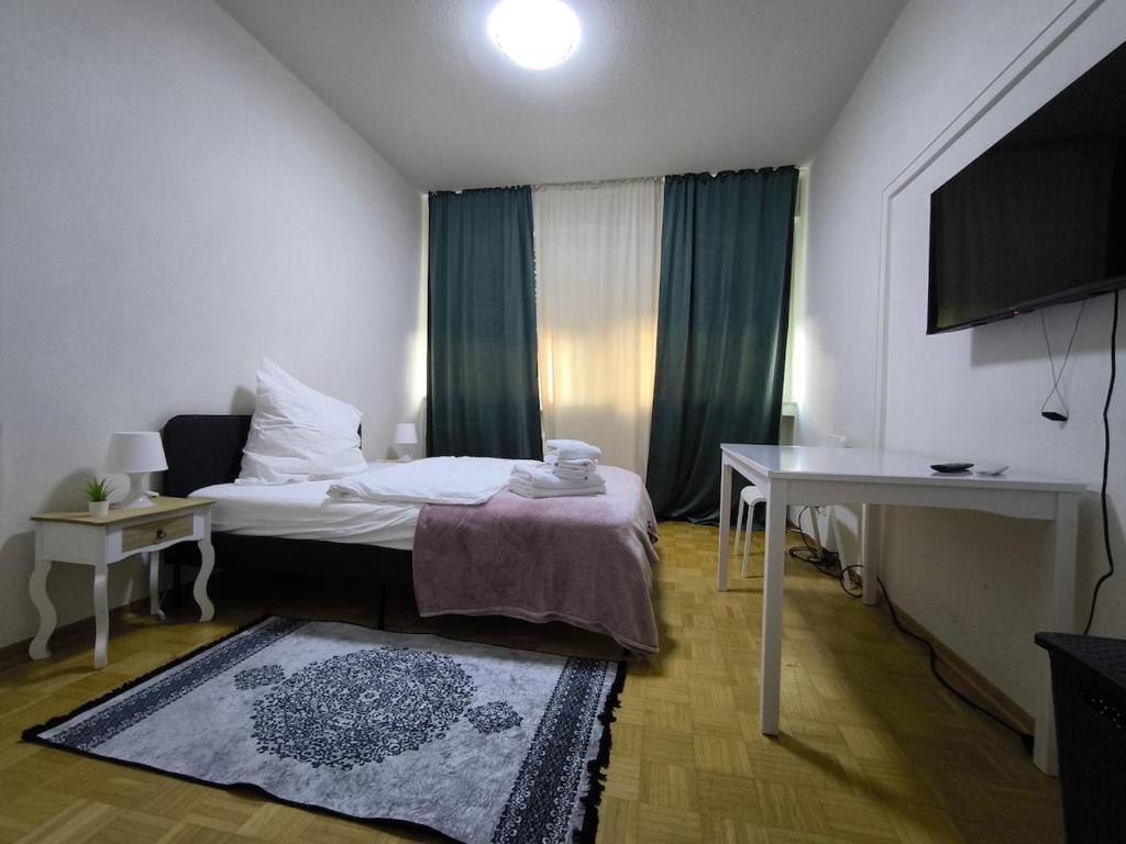 a room with a bed and a table and a television at FEWO Leonie 3 Schlafzimmer Apartment in Hückeswagen