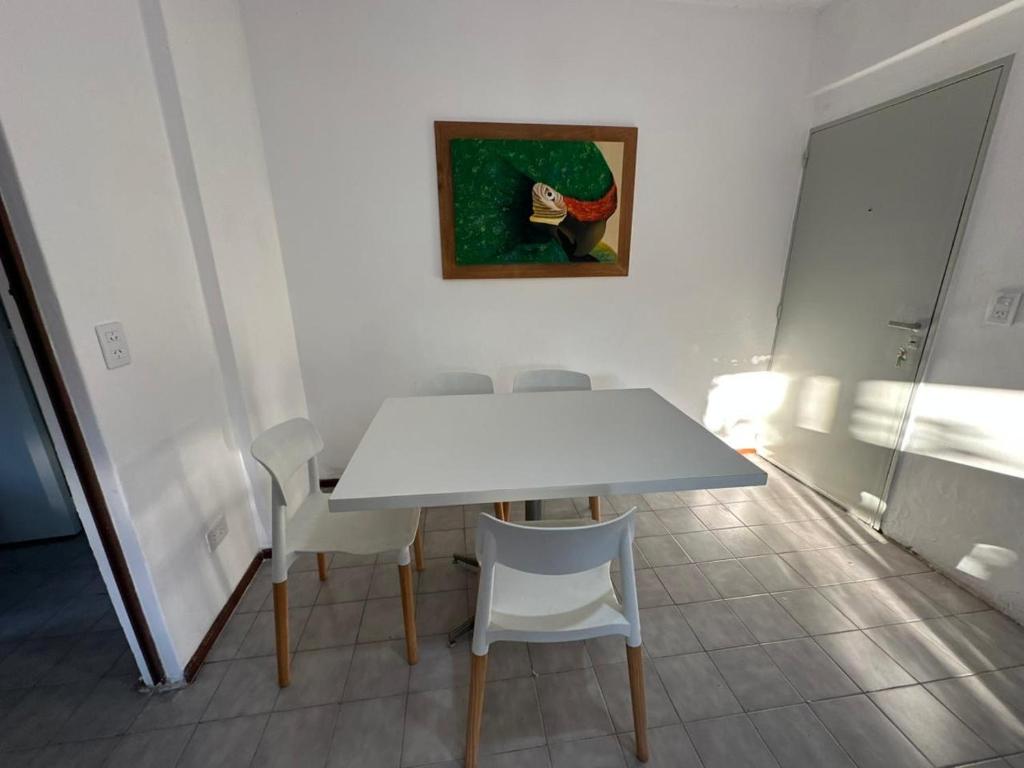 a white dining room table with chairs and a painting at La Pausa Misiones in Posadas