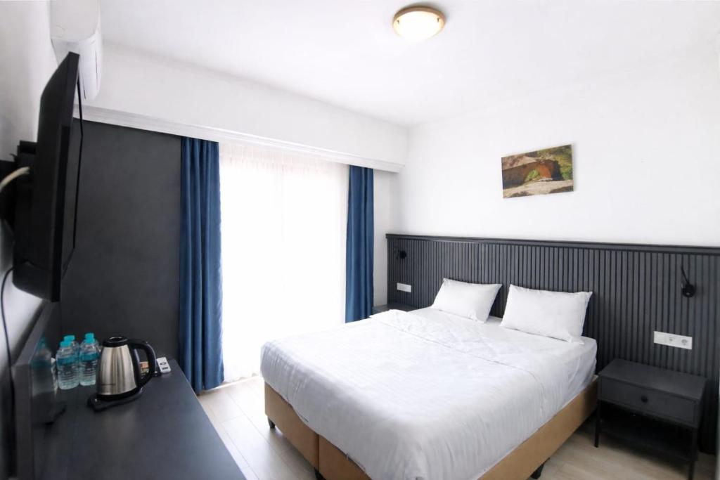 a bedroom with a bed and a desk with a television at The Yücedağ Hotel in Arapkir