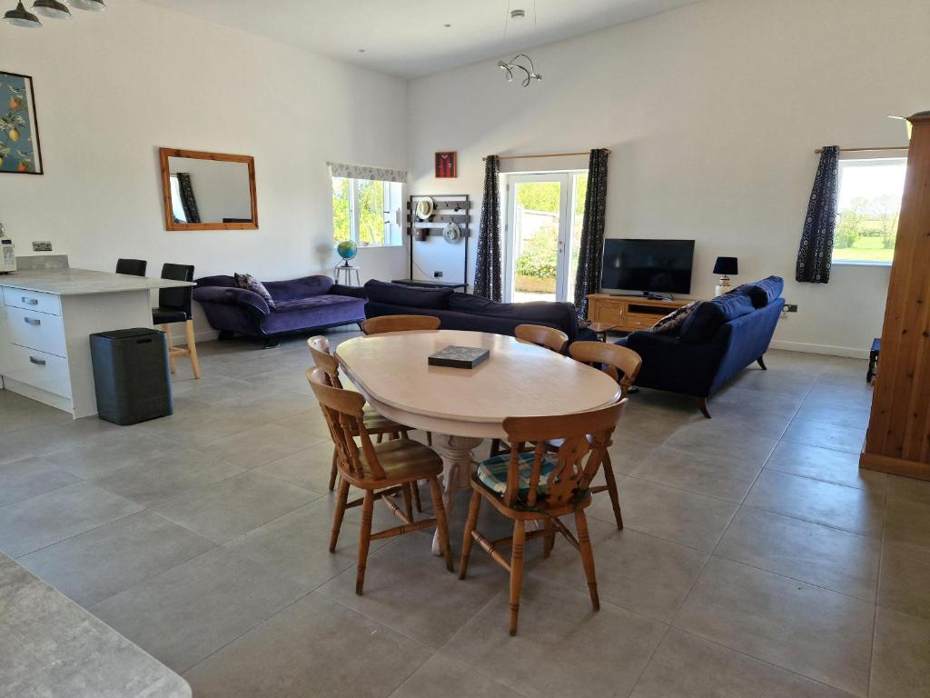a living room with a table and chairs at Mortimers Farm Barn in Saffron Walden