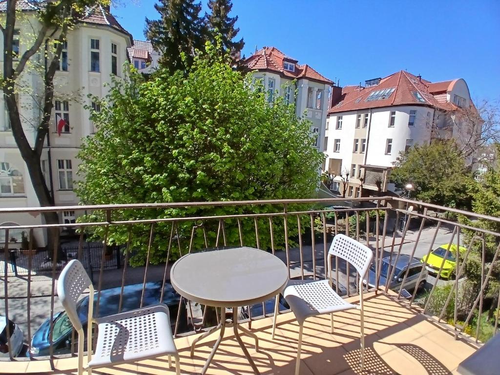 a balcony with a table and chairs and buildings at Pokoje z balkonami & Parking, 300m do Molo in Sopot