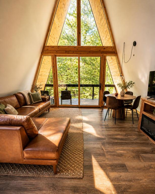a living room with a couch and a table at Black Gum Getaway-Cozy Forest A-frame Near Bentonville in Rogers