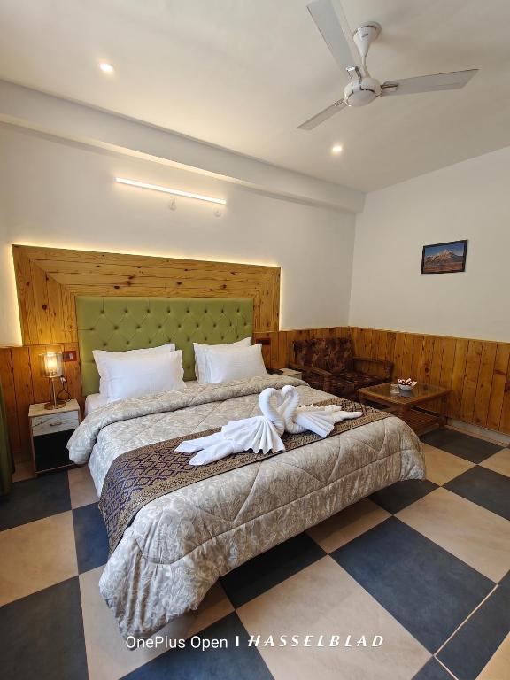 a bedroom with a bed with a robe on it at Mountain Orchid in Manāli
