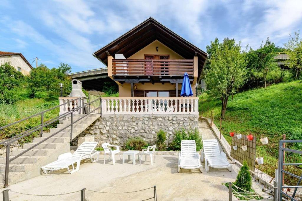 a house with white chairs and a house at Vintage house Jablanica Lake in Železnička Stanica Jablanica Grad
