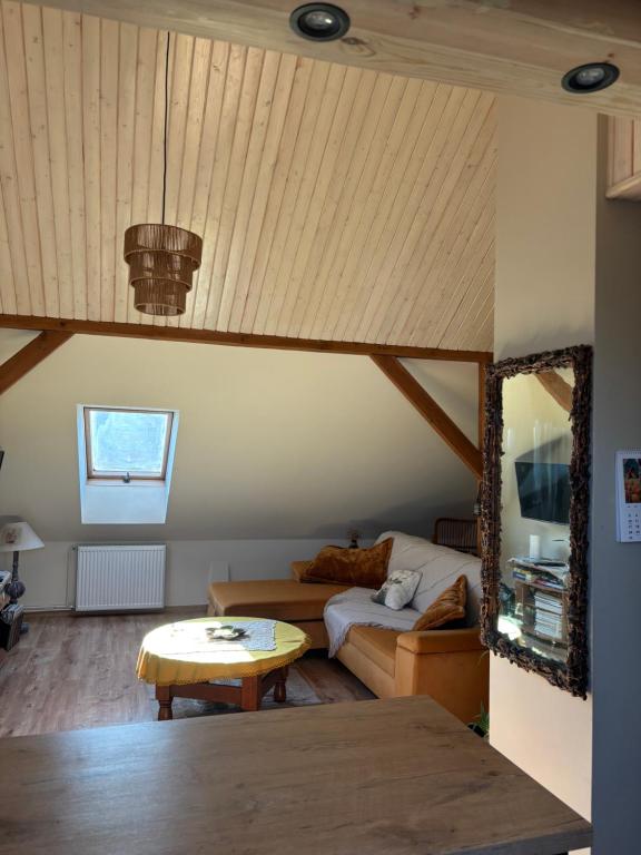 a living room with a couch and a table at Apartament 2-pokojowy, z atrakcjami dla dzieci in Kolonia Salnia