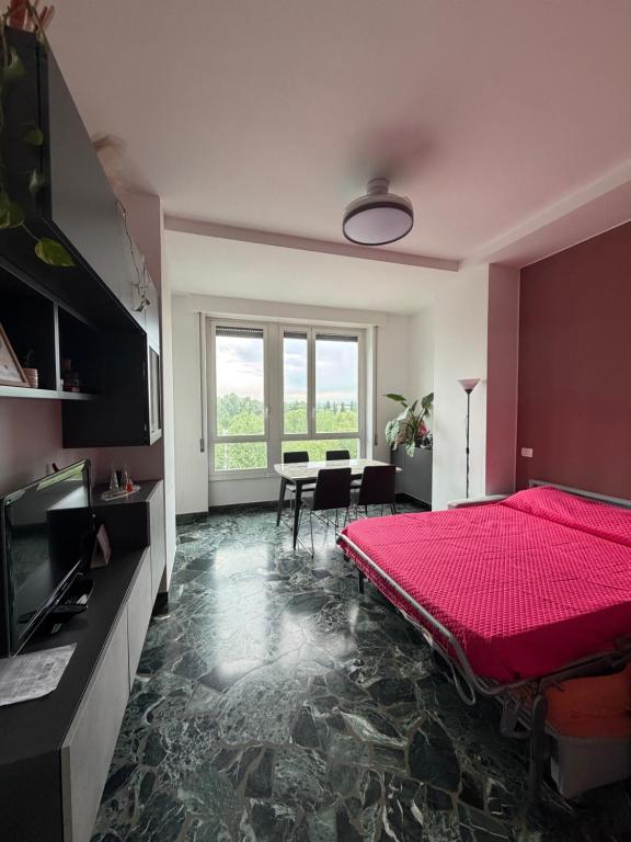 a bedroom with a red bed and a table at STANZA matrimoniale metro M5 - Bignami, Carroponte in Sesto San Giovanni