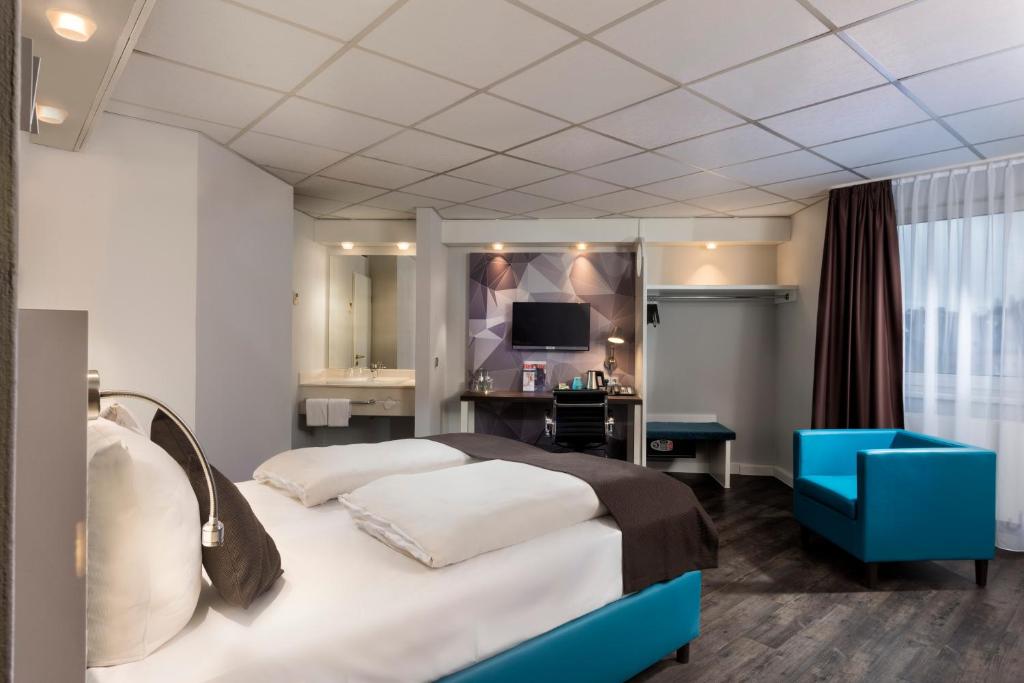 um quarto de hotel com uma cama, uma secretária e uma televisão em Best Western Hotel Cologne Airport Troisdorf em Troisdorf