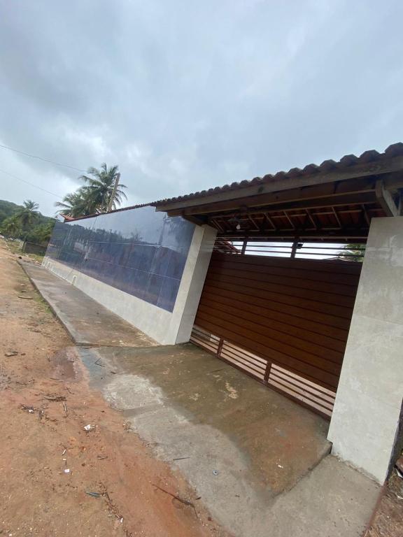 a building with a large wall next to a dirt road at Recanto MARES DO SUL in Coruripe