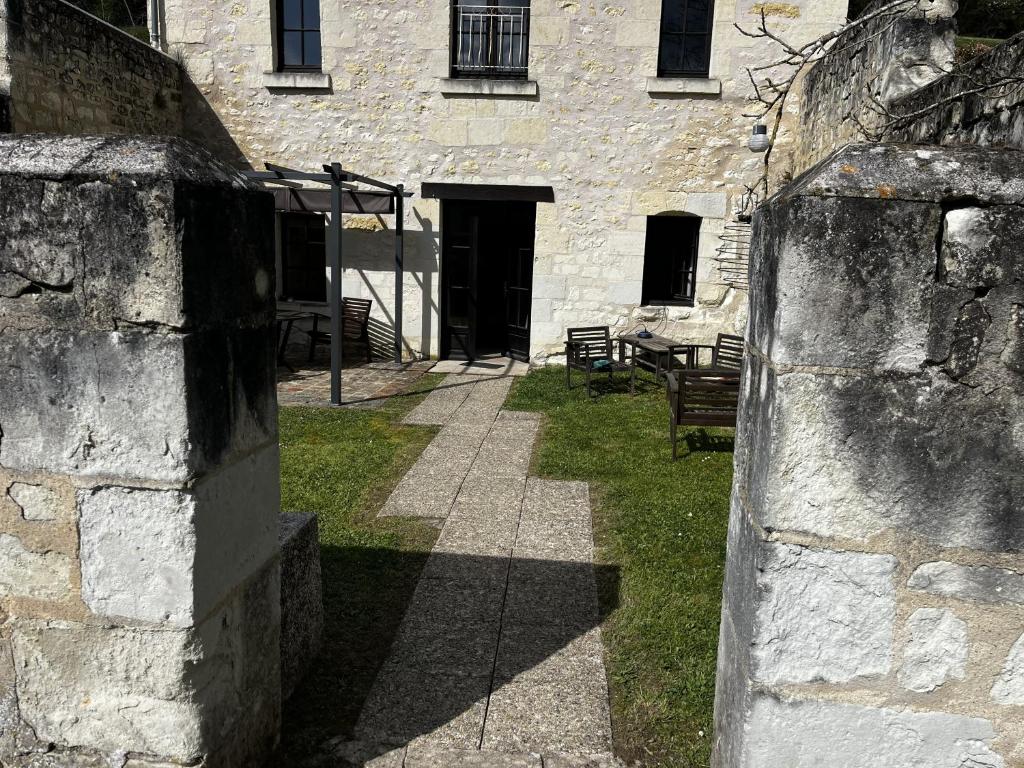 a stone building with a table and chairs in front of it at Studio La Parenthèse in Chinon