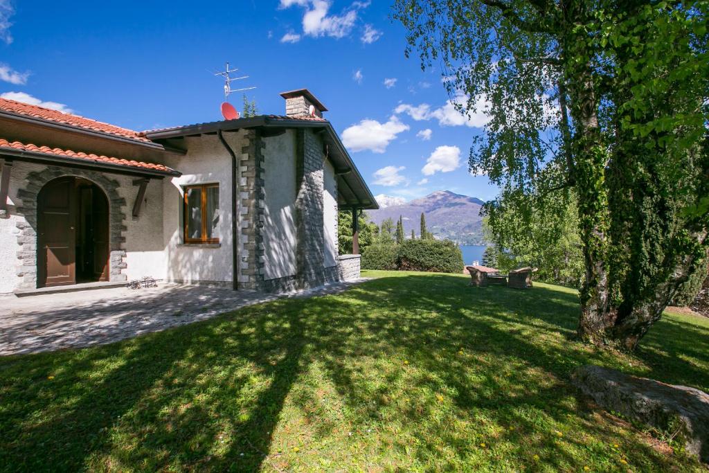 メナッジョにあるVilla Giardino di Menaggioの湖畔の芝生の庭のある家