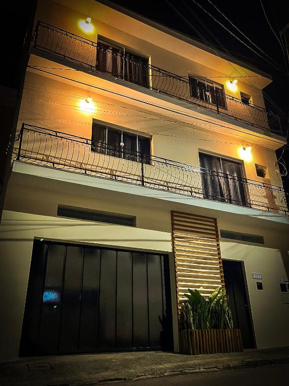 a building with a gate and a balcony at night at Apartamentos C7 in Cunha