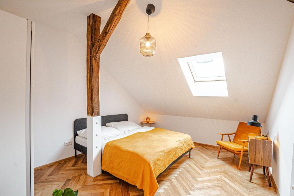 a bedroom with a bed and a tree in the ceiling at Podkrovní Apartmán in Třebíč