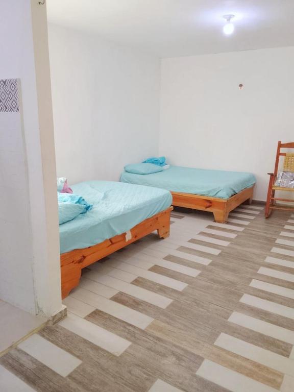 two beds are sitting in a room with a floor at Two-Bedroom Apartment with Ocean View in La Ciénaga
